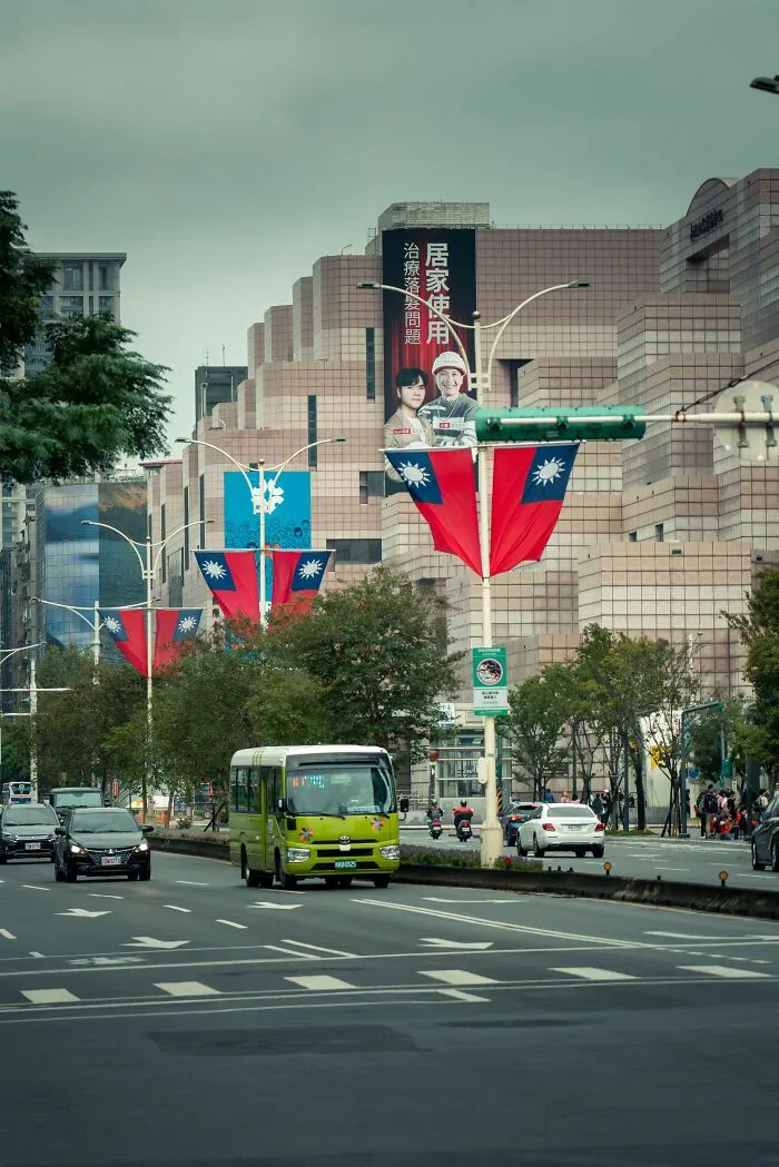 A city street with buildings and flags, reflecting cultural differences and potential misunderstandings between locals and foreigners.
