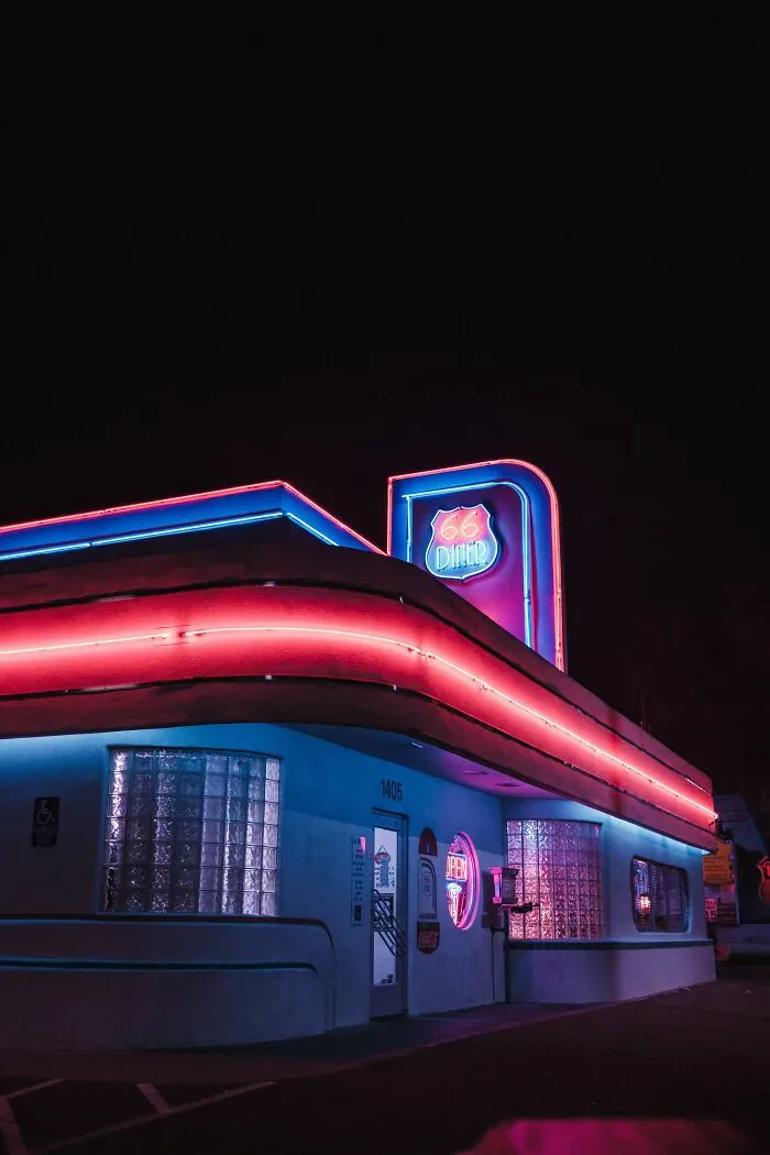 A neon-lit diner building at night, showing the vibrant atmosphere that might lead to misunderstandings for foreigners.