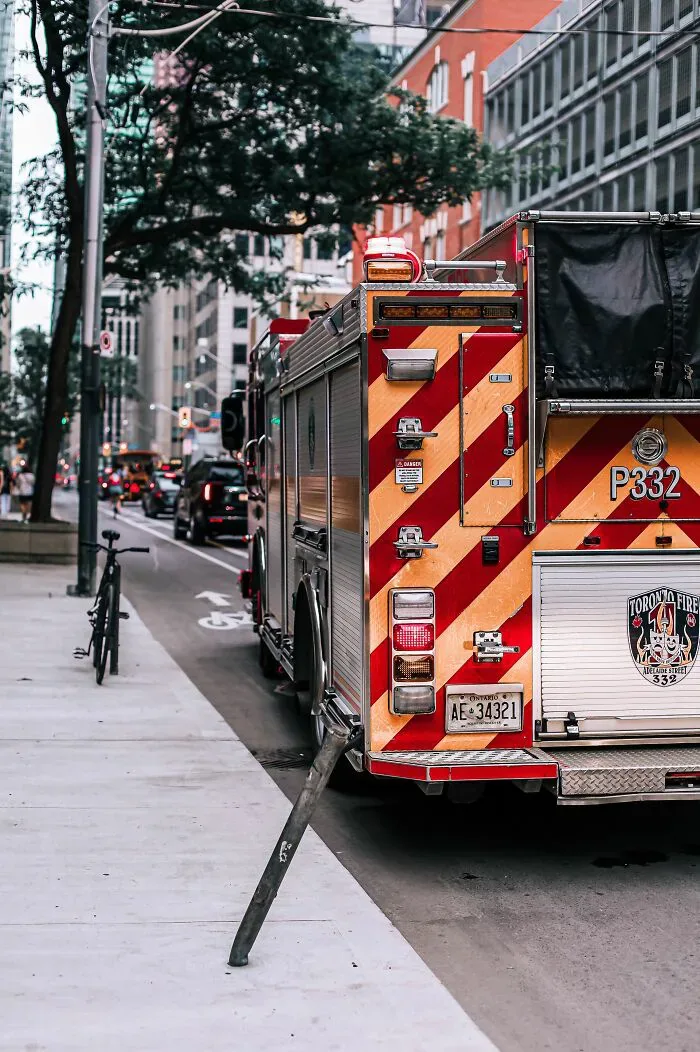 A red and yellow fire truck parked on a city street, reflecting potential misunderstandings between locals and foreigners.