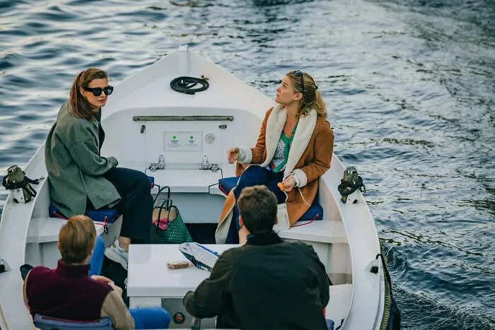 Four people in a small boat on the water, illustrating potential misunderstandings that can arise between locals and foreigners.