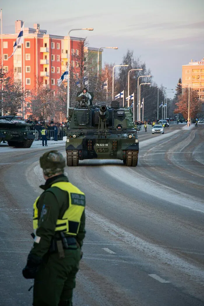 Military tanks parade on a snowy street, showing potential misunderstandings between locals and foreigners.